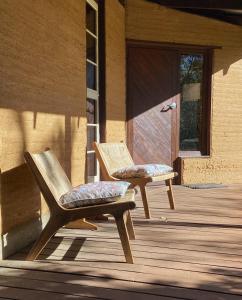 two wooden chairs sitting on a porch with a door at Eucalyptus House in Pemberton