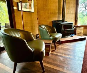 a living room with two chairs and a stove at Eucalyptus House in Pemberton