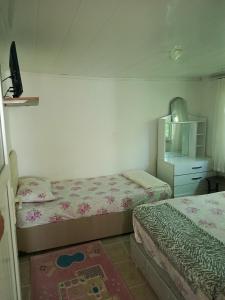 a small bedroom with two beds and a dresser at Ocaklar Torunlar Apart in Erdek