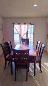 a dining room table with four chairs and a window at Riverside Holiday Arartment in Sigatoka