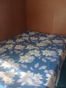 łóżko z niebieskim kocem z białymi kwiatami w obiekcie AAIZ Homestay w mieście Labasa Airport