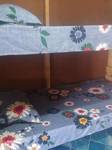 łóżko z niebieską kołdrą w kwiaty w obiekcie AAIZ Homestay w mieście Labasa Airport