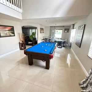 a living room with a pool table in it at Luxury and Comfort in Coconut Creek