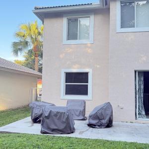 a group of gray tarp chairs in front of a house at Luxury and Comfort in Coconut Creek