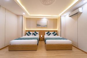a hotel room with two beds in a room at Green Airport Hotel 2 in Ho Chi Minh City