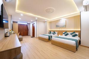 a hotel room with two beds and a television at Green Airport Hotel 2 in Ho Chi Minh City