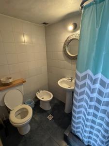 a bathroom with two toilets and a sink and a shower curtain at Bolson deptos in El Bolsón +27 photos