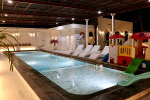 a indoor swimming pool with a toy train and a playground at Hotel Roditha Banjarbaru in Banjarbaru