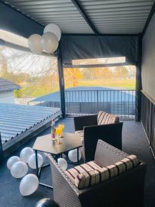 a screened porch with a table and chairs and balloons at Linies guest house northmead in Benoni