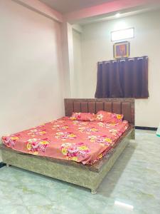 a bed with a red comforter in a room at Hotel Arpita in Ashta