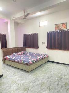 a bedroom with a bed in a room with curtains at Hotel Arpita in Ashta