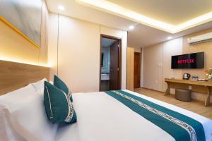 a hotel room with a bed and a flatscreen tv at Green Airport Hotel 2 in Ho Chi Minh City