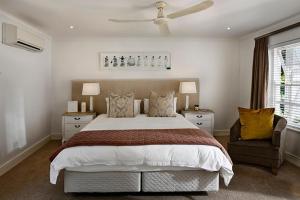 a bedroom with a large bed and a chair at Peralam Rooms in Peralam Junction