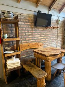 a room with a table and a tv on a brick wall at Bolson deptos in El Bolsón