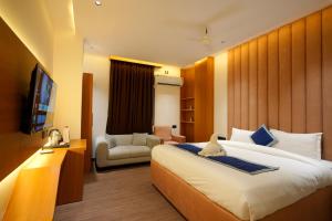 a hotel room with a large bed and a couch at Shiv Rudraksh Resort, Near Assi Ghat in Varanasi