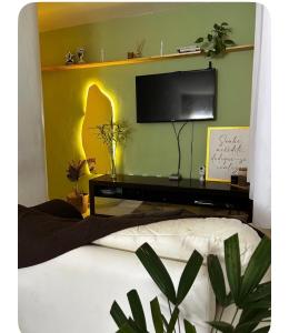 a bedroom with a bed with a tv on a wall at Garanhuns casatres123 in Garanhuns