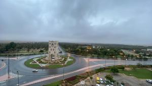 a building with a clock tower on a road at Nahda Tower Suite in Salalah