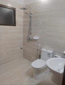 a bathroom with a toilet and a sink and a shower at Nahda Tower Suite in Salalah
