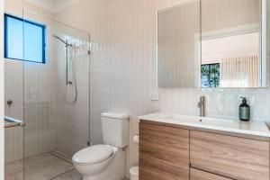 a bathroom with a toilet and a sink and a shower at Fernleigh Stay in Fernleigh +20 photos