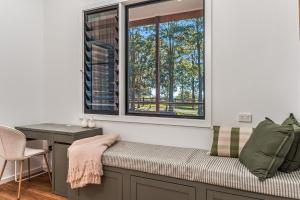 a room with a window and a bench with a desk at Fernleigh Stay in Fernleigh
