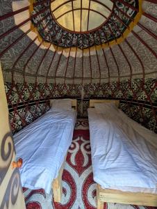 a small bedroom with two beds in a yurt at Altyn Sky in Mineralʼnyy Istochnik Altyn-Arasan +12 photos