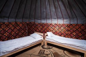a room with two beds in a yurt at Altyn Sky in Mineralʼnyy Istochnik Altyn-Arasan