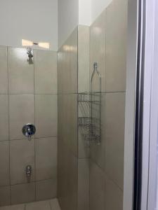 a shower stall with a glass door with a shower at Golden Isles Paradise in Port-of-Spain +8 photos