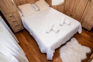 a bed with four pillows on it in a room at Apartament Ritmului in Zalău