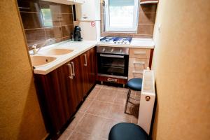 a small kitchen with a sink and a stove at Apartament Ritmului in Zalău