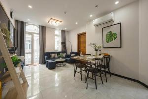 a kitchen and living room with a table and chairs at Amy Apartment Hue in Hue