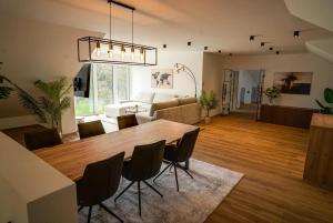 a dining room and living room with a table and chairs at Das Freyenstein in Berghof