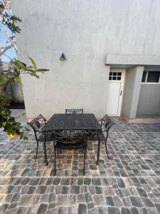a black table and chairs on a brick patio at Temporario Martínez in General Pico