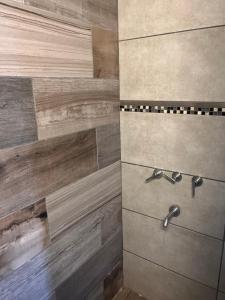 a bathroom with a shower with wooden tiles at Temporario Martínez in General Pico