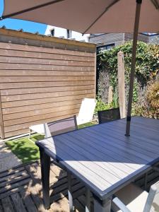 a blue table with an umbrella on a patio at gîte des eiders 5 mn de la plage in Quiberon
