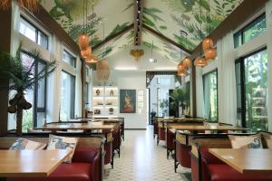 a dining room with tables and chairs and windows at HuzhouGiraffe ManorHotel in Huzhou