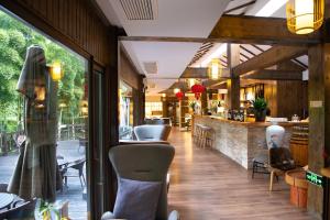 a restaurant with a bar and chairs in a room at HuzhouGiraffe ManorHotel in Huzhou