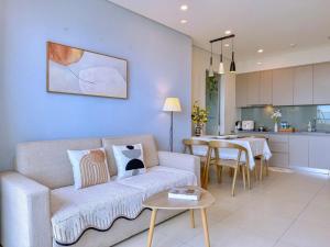 a living room and kitchen with a couch and a table at The Song Suites Apartment Vung Tau - Căn Hộ Du Lịch 5 Sao Cạnh Biển in Vung Tau