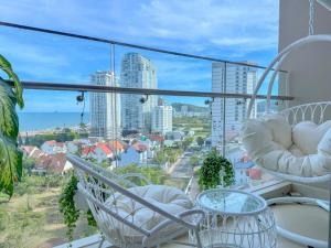a balcony with chairs and a view of the city at The Song Suites Apartment Vung Tau - Căn Hộ Du Lịch 5 Sao Cạnh Biển in Vung Tau