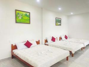 three beds in a room with white walls at Boho NHH Apartment in Hanoi