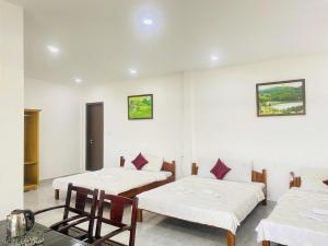 a room with two beds and a table and chairs at Boho NHH Apartment in Hanoi
