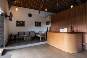 a restaurant with a counter and couches in a room at Druwa Bali in Uluwatu