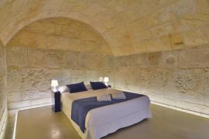 a bedroom with a bed in a stone wall at Lonja Suites Apartments in Palma de Mallorca