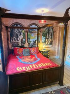 a bedroom with a bed with a red comforter at Harry Potter feature room- Warner bros studios in Watford +12 photos