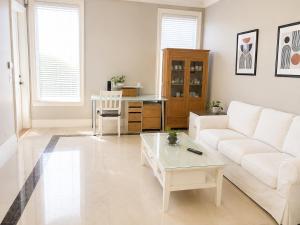 a living room with a white couch and a coffee table at Richmond 2-Bedroom Luxry Suite in Richmond