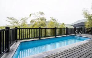 a swimming pool on a deck with a black fence at HuzhouGiraffe ManorHotel in Huzhou