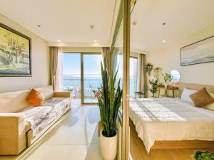 a bedroom with a large bed and a couch at The Song Suites Apartment Vung Tau - Căn Hộ Du Lịch 5 Sao Cạnh Biển in Vung Tau