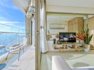 a room with a balcony with a view of the ocean at The Song Suites Apartment Vung Tau - Căn Hộ Du Lịch 5 Sao Cạnh Biển in Vung Tau