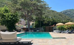 a swimming pool with lounge chairs next to a resort at A Villa Rosa in Santa-Maria-di-Lota