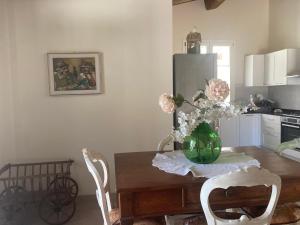 a dining room table with a vase of flowers on it at Villa sport relax in Colle di Val d'Elsa