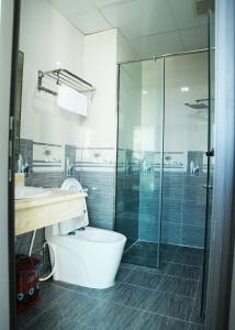 a bathroom with a toilet and a glass shower at Thăng long II Hotel flc sầm sơn Thanh Hóa in Sầm Sơn
